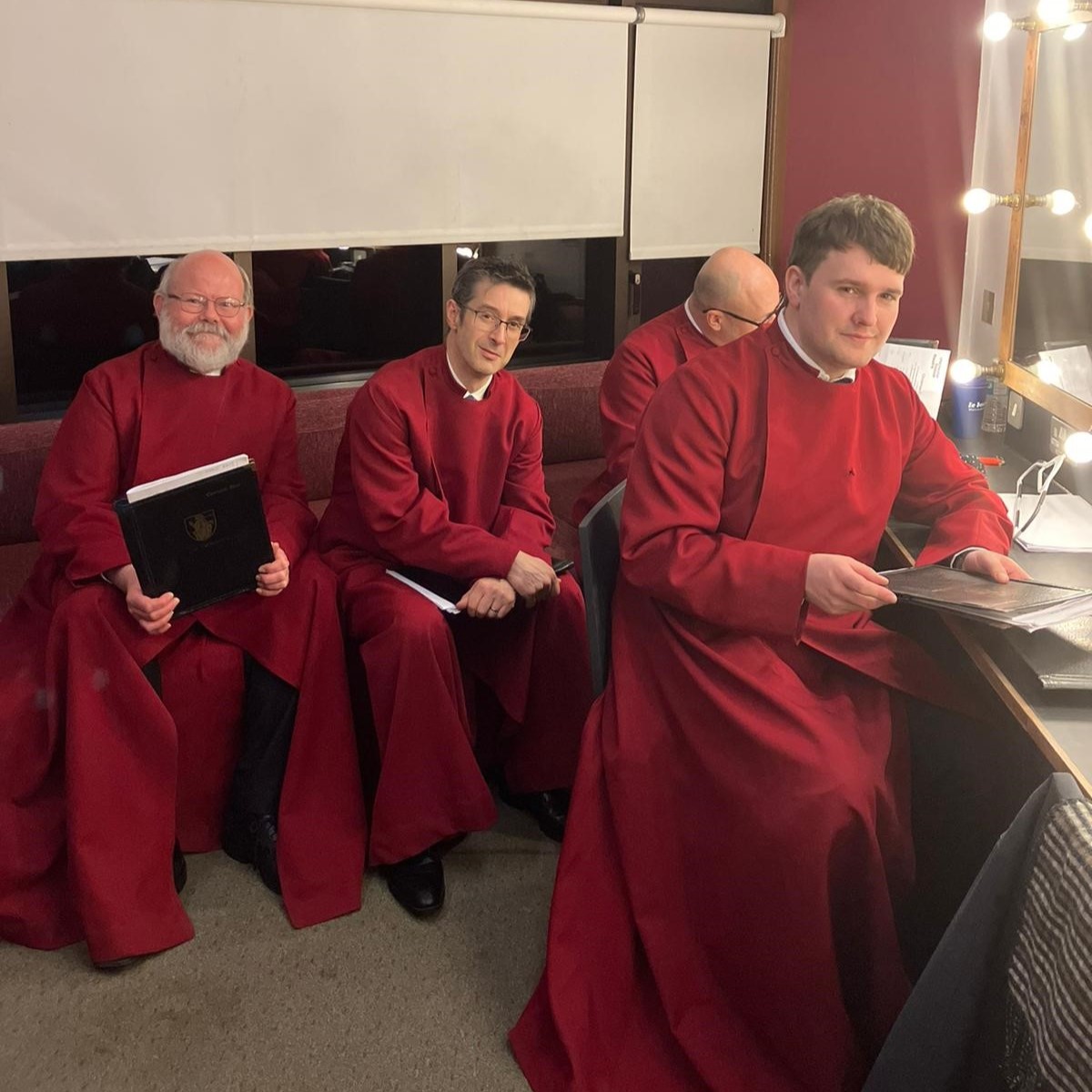 4 lay Vicars prepare for the concert dressed in red cassocks