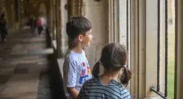 2 children in the Cloisters look into Paradise, a green space